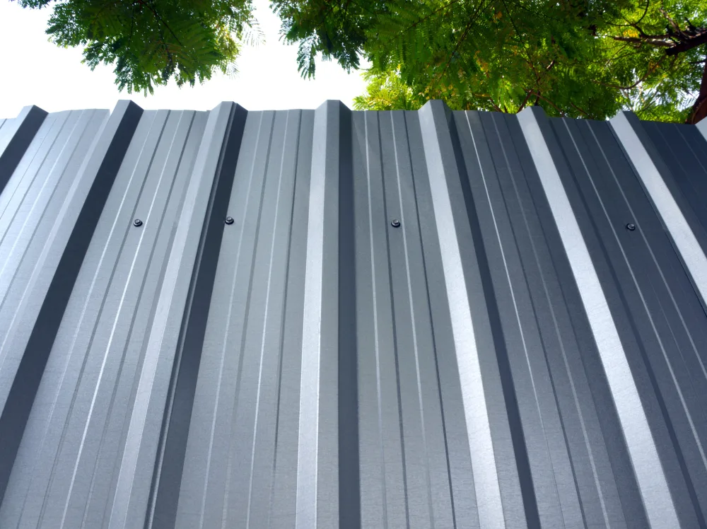 Ribbed metal roofing panels with exposed fasteners