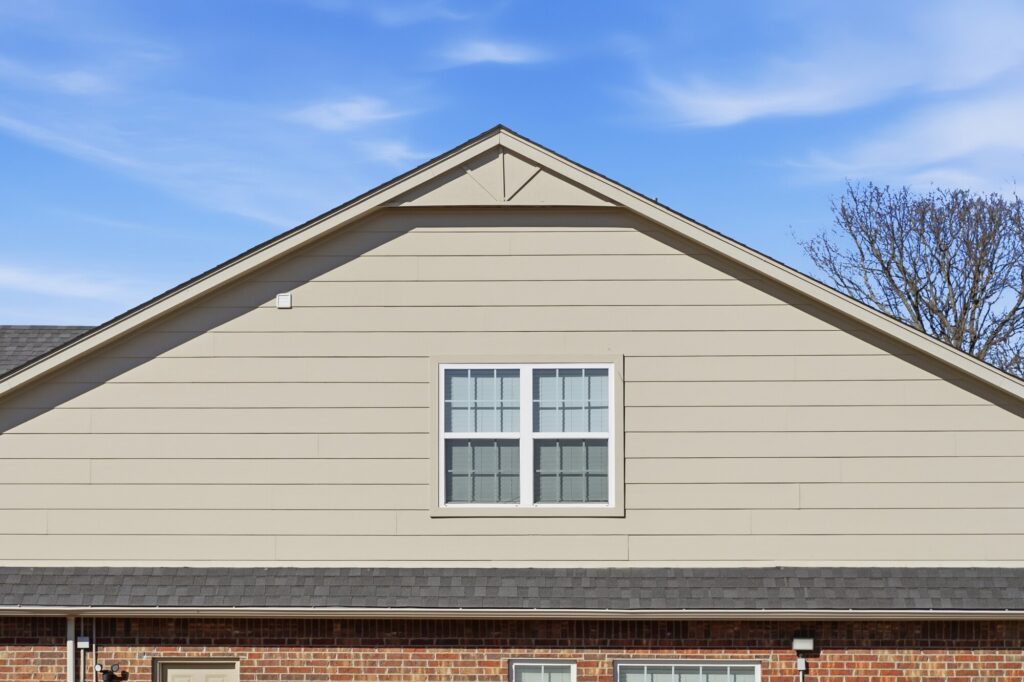 Gable end and roofline above a brick home with a completed shingle roof