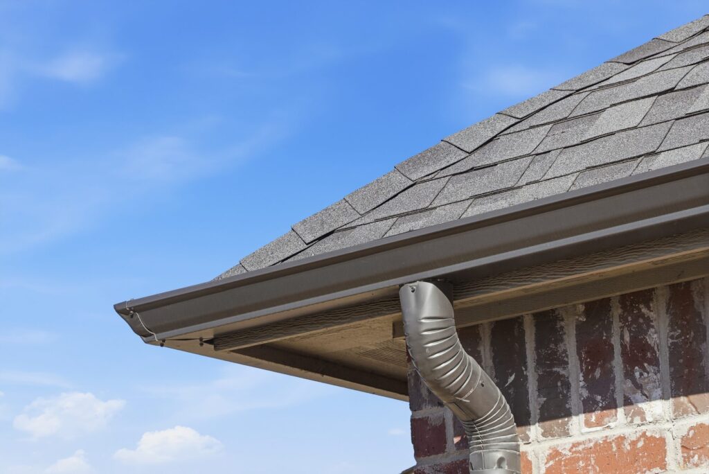 Seamless gutter and downspout installed on a roofline